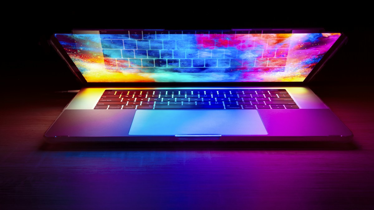 Ordinateur portable ouvert, écran et clavier éclairés de couleurs vives